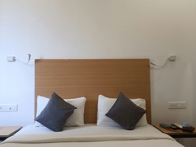 Two single beds side by side with white sheets and pillows