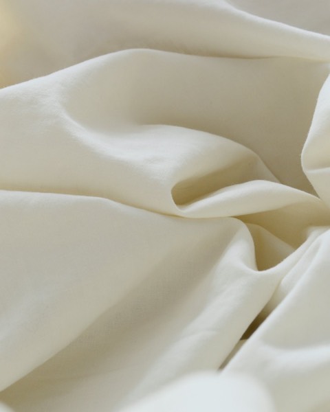 Soft folds of white cotton sheeting